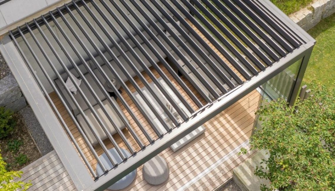 Draufsicht auf ein SKL 100 Lamellendach in Malters, Luzern, mit Glaswänden und 300 kg/m² Schneelast – moderner Outdoor-Wohnbereich mit Schatten- und Lichtspiel.