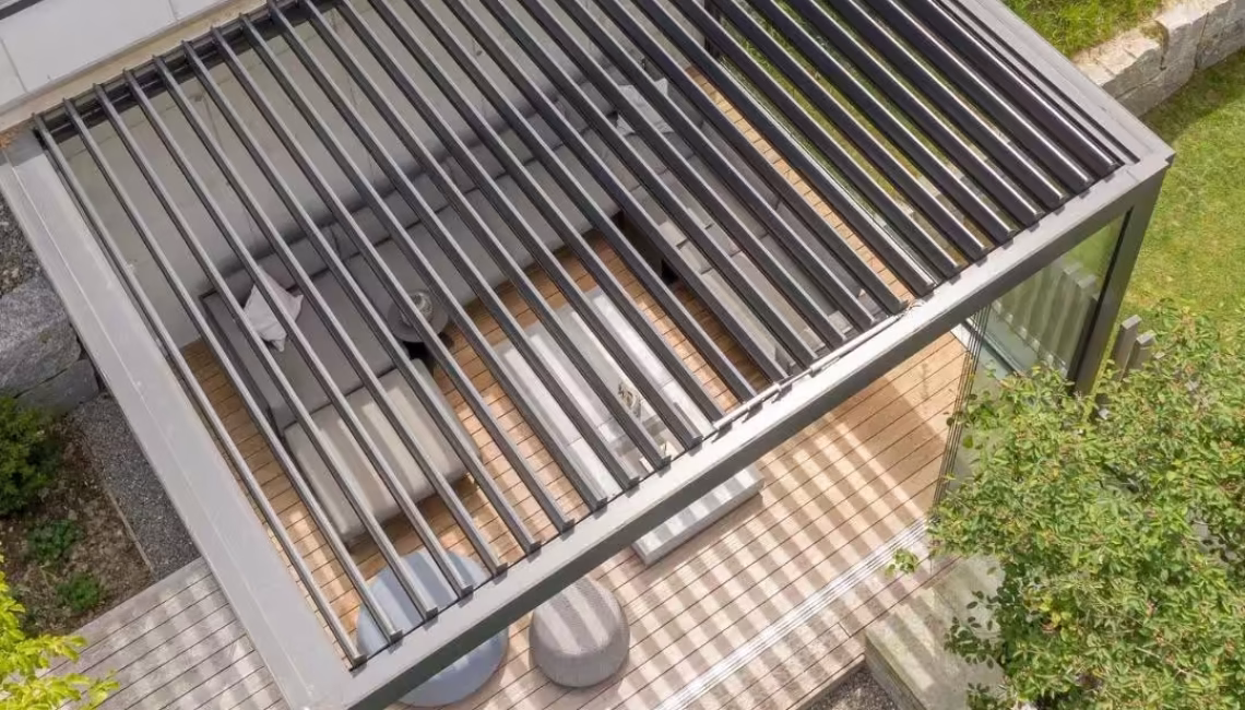 Draufsicht auf ein SKL 100 Lamellendach in Malters, Luzern, mit Glaswänden und 300 kg/m² Schneelast – moderner Outdoor-Wohnbereich mit Schatten- und Lichtspiel.