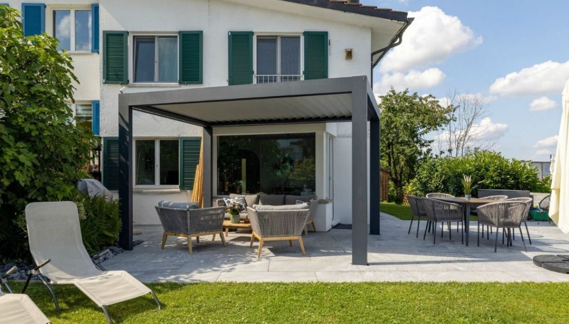 Lamellendach SKL 100 in Rümlang Zürich – moderne Terrassenüberdachung mit 300 kg/m² Schneelast und gemütlicher Einrichtung.