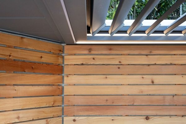 Detailaufnahme eines SKL 50 SKY Lamellendachs mit Holzverkleidung und integrierter LED-Beleuchtung.