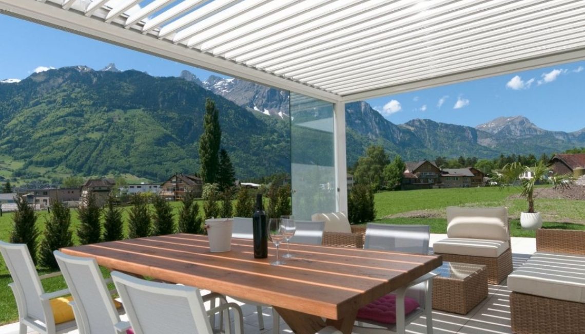 SKL 100 Lamellendach in Schattdorf, Uri – weisse Aluminiumkonstruktion mit Blick auf die Berge, ausgestattet für 300 kg/m² Schneelast.