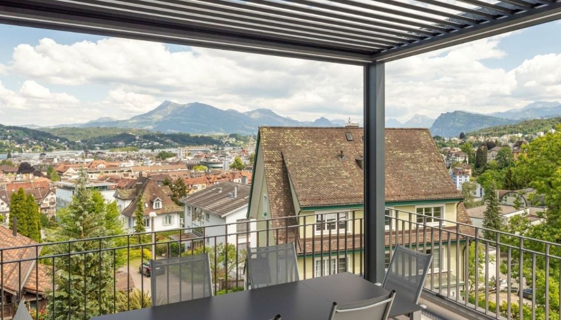 SKL 140 Lamellendach auf einer Terrasse in Luzern mit Blick über die Stadt und die umliegenden Berge.