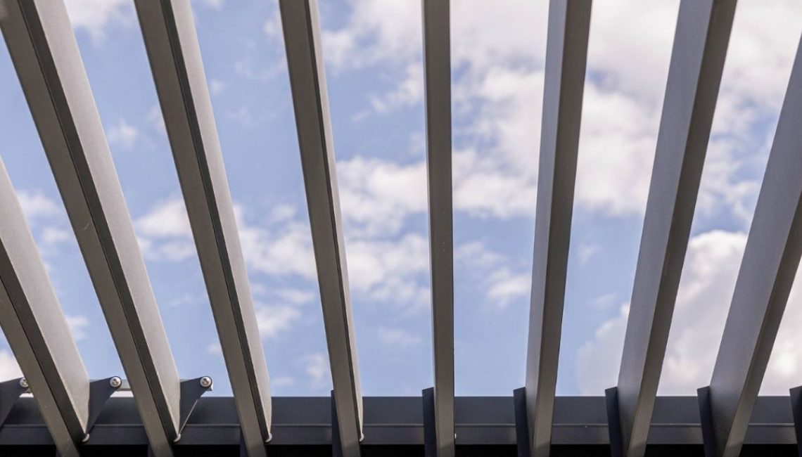Nahaufnahme der geöffneten Lamellen eines SKL 140 Lamellendachs in Luzern mit Blick in den blauen Himmel.