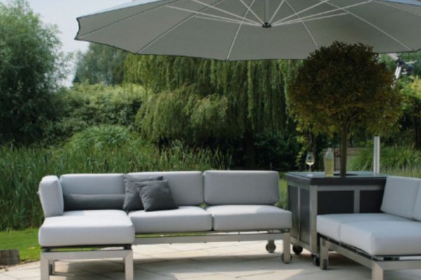 Moderner MEZZO Sonnenschirm in Grau über einer stilvollen Lounge im Garten mit Sofas und Beistelltisch.