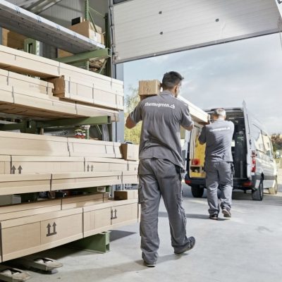 Thermogreen Monteure laden Bauteile für eine Terrassenüberdachung in das Montagefahrzeug