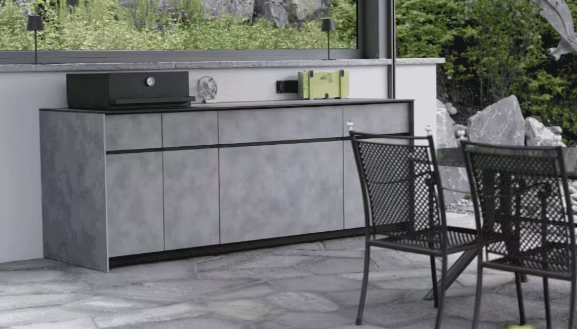 Aussenküche mit Keramikarbeitsfläche und Grill unter Überdachung mit Sitzbereich davor
