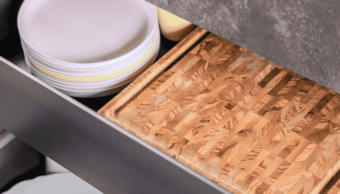 Schublade der Aussenküche Theiss Avers in Stäfa mit Geschirr und Holzschneidebrett unter HPL Arbeitsfläche