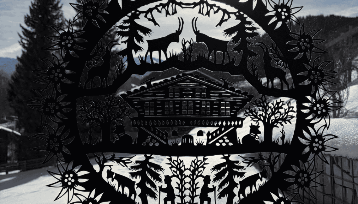 Dekoratives Metallelement mit alpinen Motiven vor winterlicher Landschaft in Lenk im Simmental, aufgenommen im Umfeld eines privaten Terrassenprojekts.