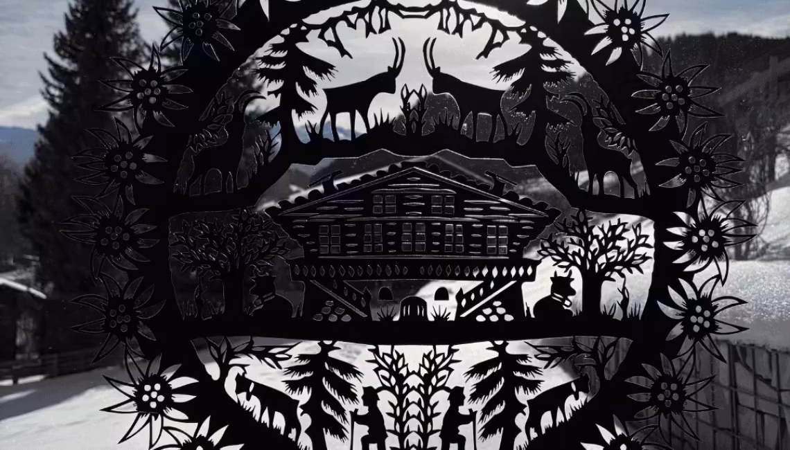 Dekoratives Metallelement mit alpinen Motiven vor winterlicher Landschaft in Lenk im Simmental, aufgenommen im Umfeld eines privaten Terrassenprojekts.