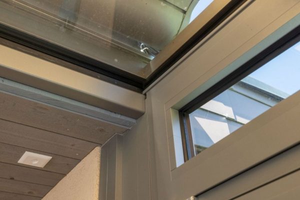 Detailaufnahme des Glasdachs SGL 1 am Hausanschluss mit Fenster, präzise Abdichtung und hochwertige Verarbeitung für maximale Dichtheit.