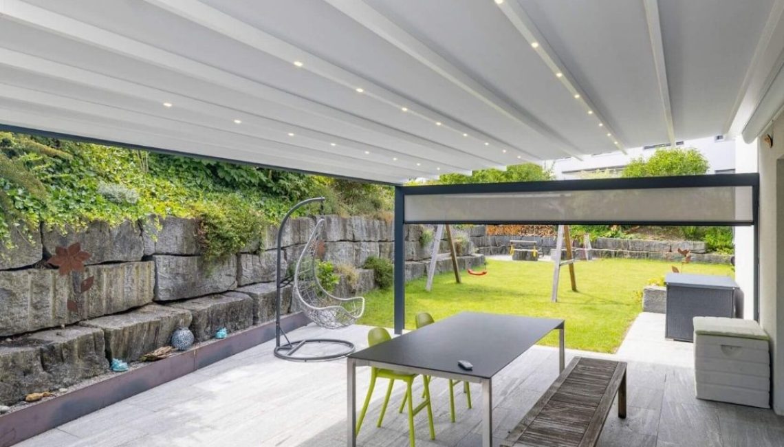 Grosszügiger Sitzplatz in Henggart mit modernem Textildach, LED-Beleuchtung und Ausblick in den Garten.