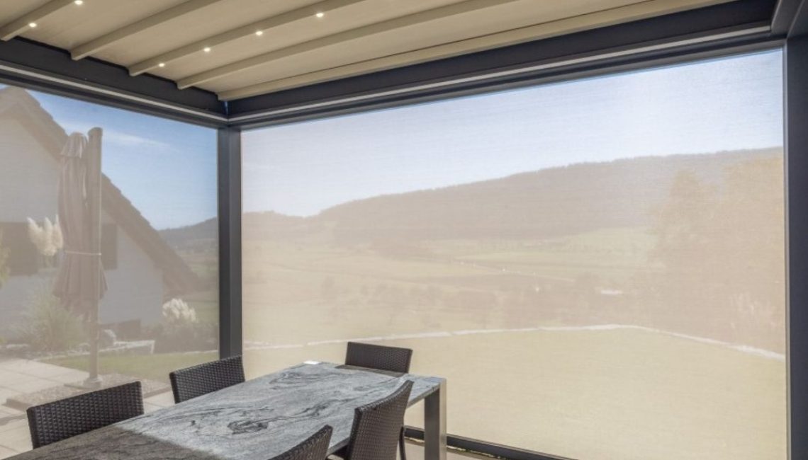 Textildach mit LED-Beleuchtung und geschlossenen Senkrechtmarkisen – Essplatz mit Naturstein-Tisch, 100% wasserdicht und windstabil bis 80 km/h.