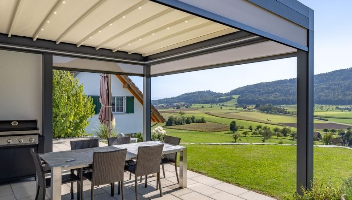 Textildach in Schöfflisdorf mit integrierter LED-Beleuchtung und automatischen Senkrechtmarkisen – moderner Essplatz mit Panoramablick ins Grüne.